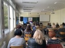 Uczestnicy spotkania zorganizowanego w ramach Płockiego Forum Gospodarczego siedzą w ławkach, na sali, tyłem do zdjęcia i słuchają wykładu.