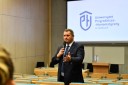 Piotr Karaś – dyrektor Wojewódzkiego Urzędu Pracy w swoimi wystąpieniu dla młodzieży mówi przez mikrofon stojąc na auli wykładowej