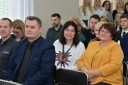 Zdjęcie przedstawia przedstawicieli różnych instytucji oraz szkół uczestniczących w targach. Na pierwszym planie widać Dyrektora siedleckiej filii Wojewódzkiego Urzędu Pracy w Warszawie, Pana Piotra Karasia, z tyłu siedzący na krzesłach ludzie.