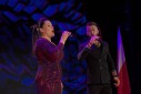 Kobieta oraz mężczyzna śpiewają na scenie